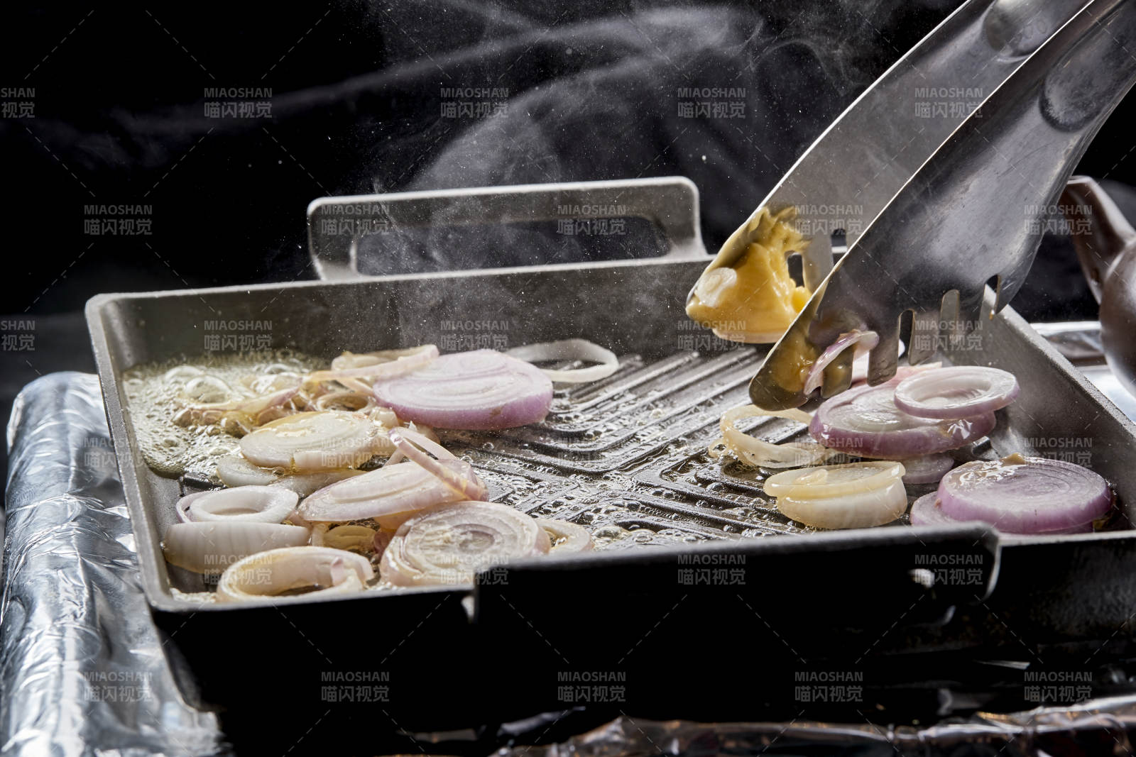 炙热的铁板上用黄油翻炒的洋葱图片