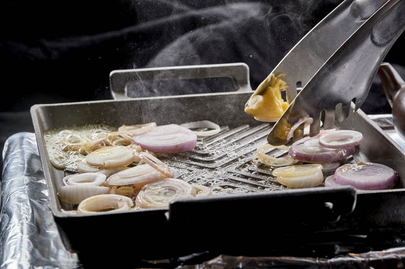 炙热的铁板上用黄油翻炒的洋葱图片