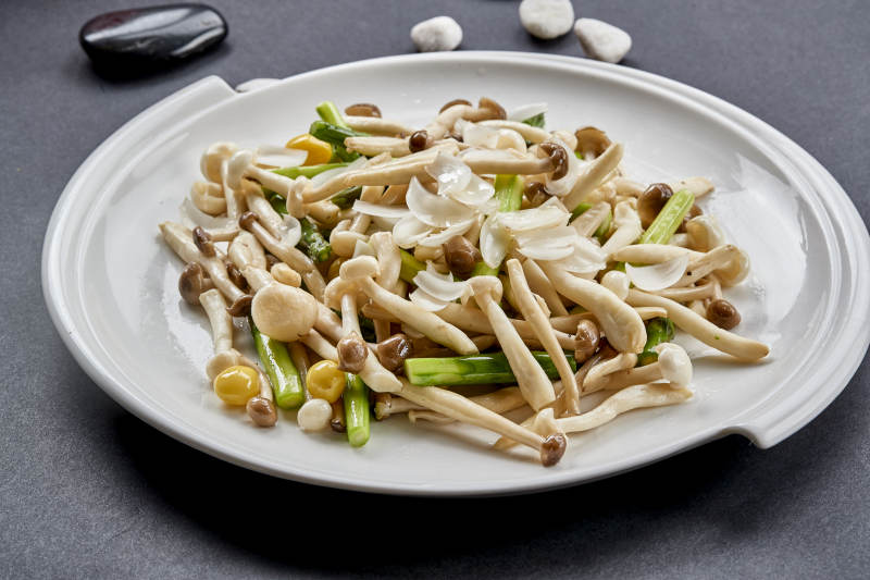 白色圆瓷盘装的菜根百合银信炒海鲜菇图片