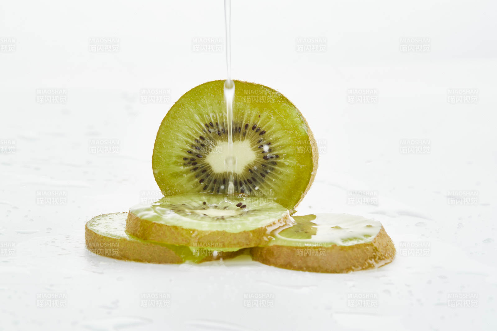 白色背景上摆放的水润猕猴桃切片图片