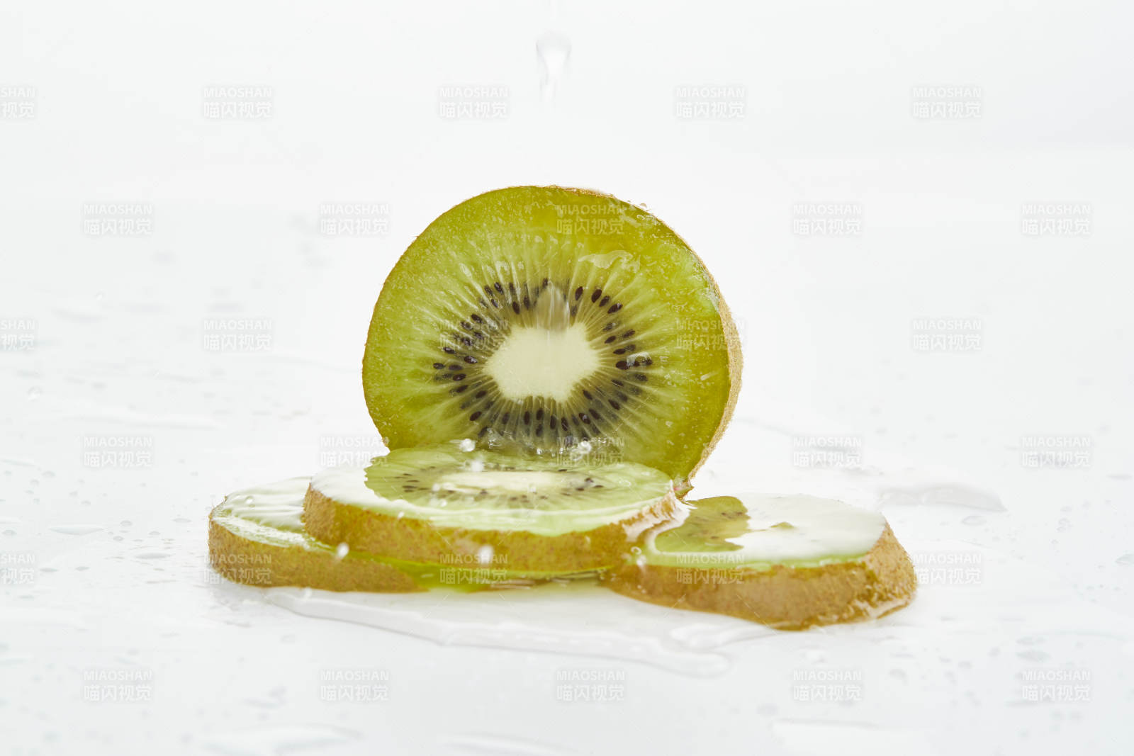 白色背景上摆放的水润猕猴桃切片图片