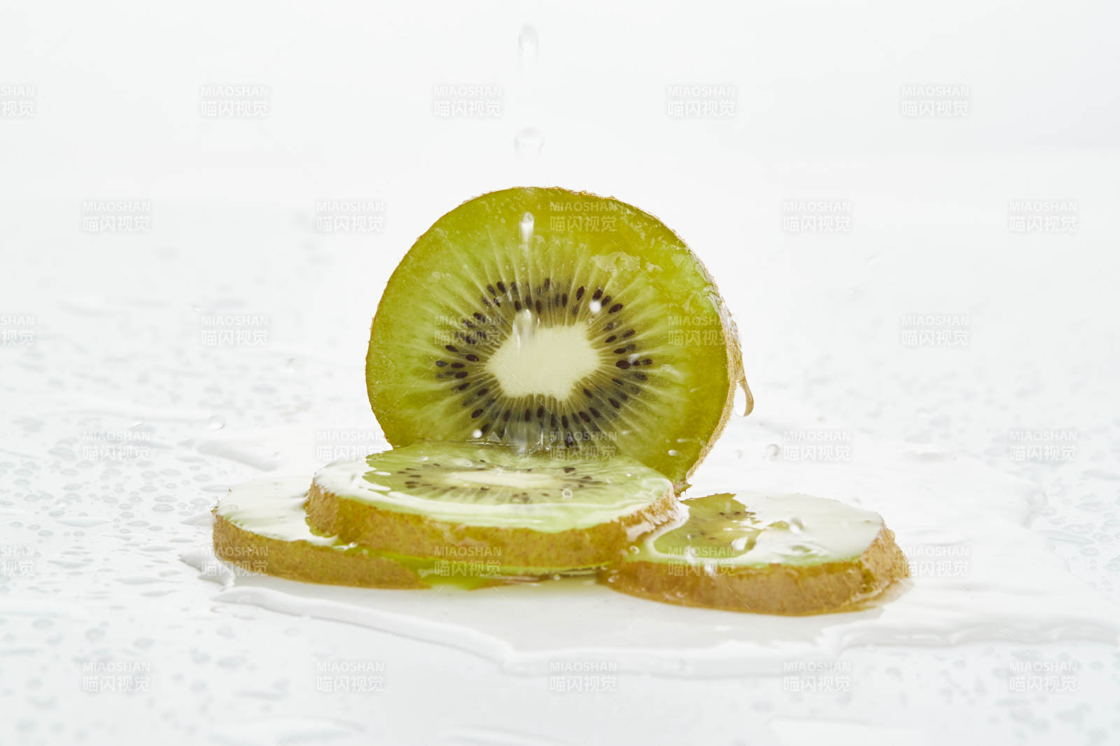 白色背景上摆放的水润猕猴桃切片图片