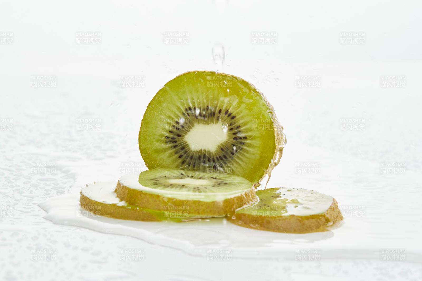 白色背景上摆放的水润猕猴桃切片图片