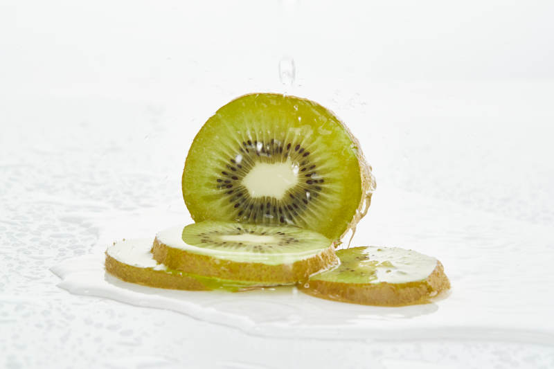 白色背景上摆放的水润猕猴桃切片图片
