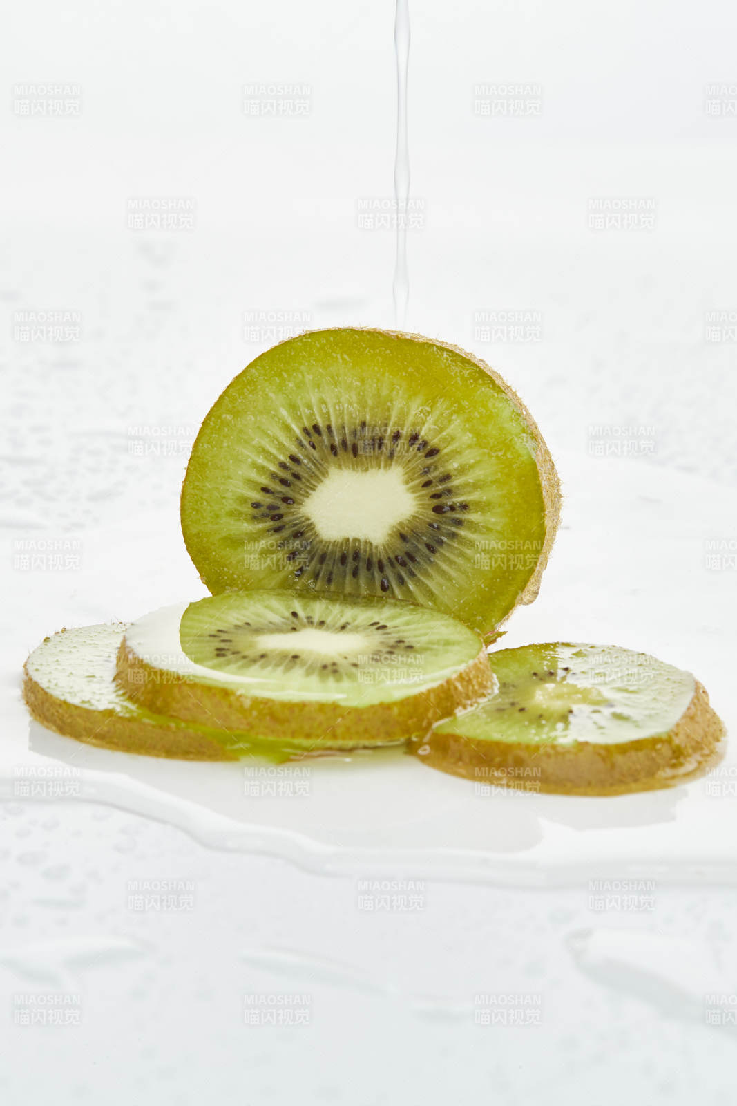 白色背景上摆放的水润猕猴桃切片图片