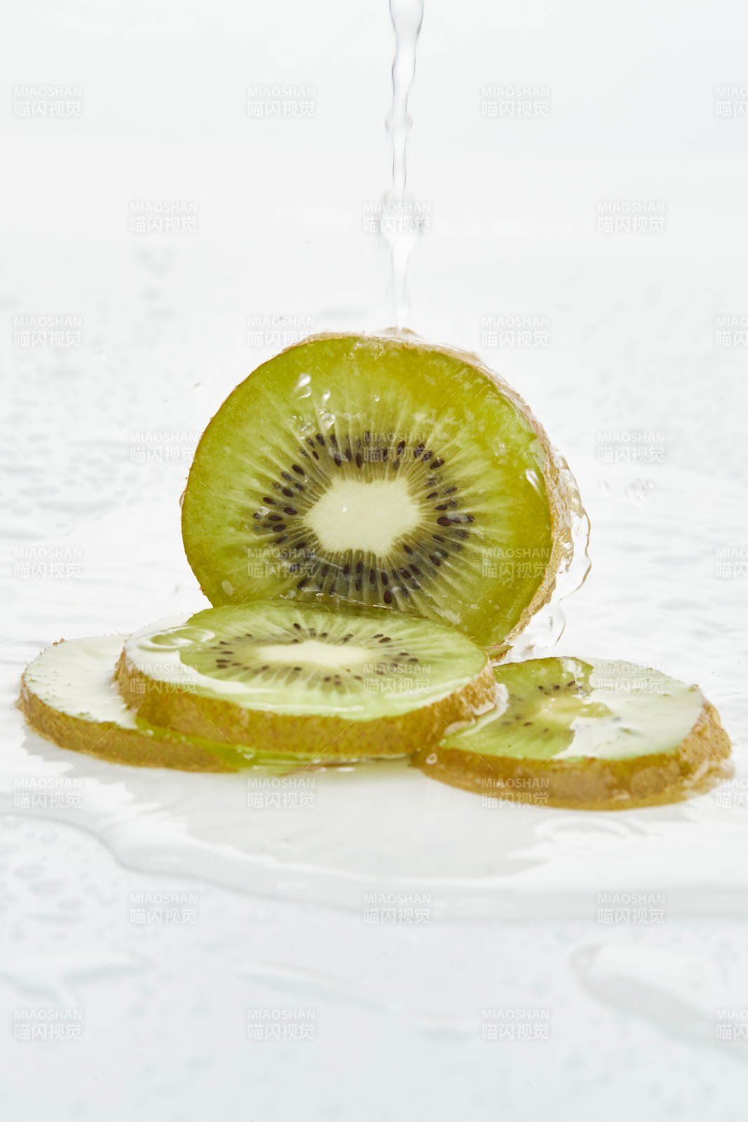 白色背景上摆放的水润猕猴桃切片图片