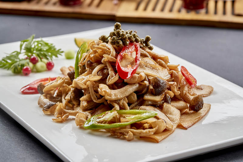 方瓷盘装的麻辣油炸鲜杂菌图片