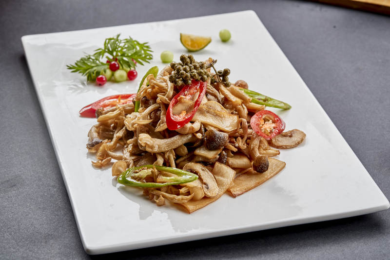 方瓷盘装的麻辣油炸鲜杂菌图片