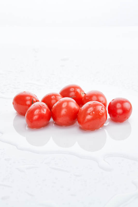 白色背景上摆放的鲜红圣女果图片