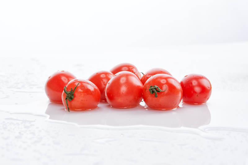 白色背景上摆放的鲜红圣女果图片