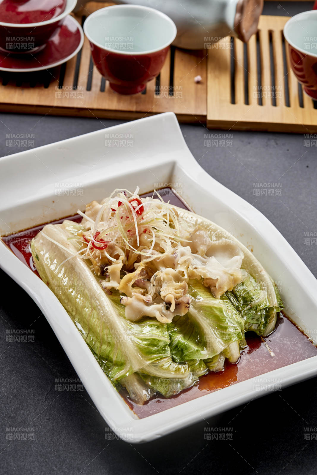 长瓷盘装的清蒸浇汁生菜螺片图片