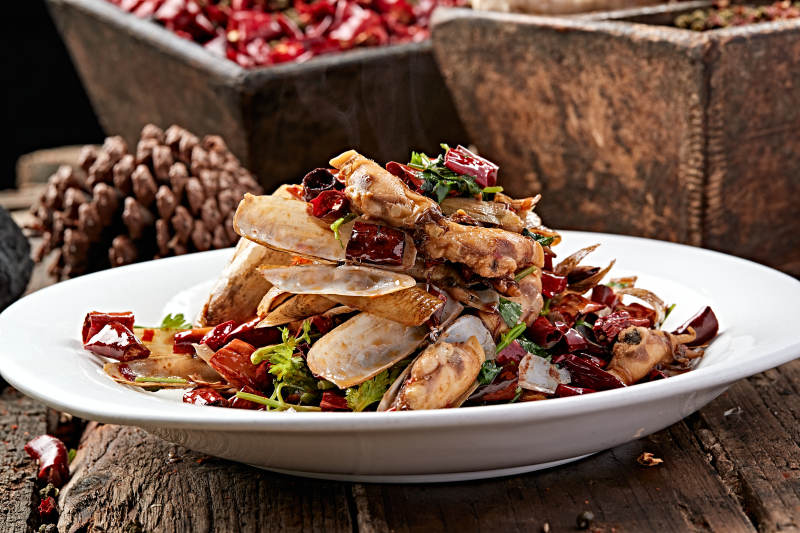 白色圆盘装的辣炒蛏子图片