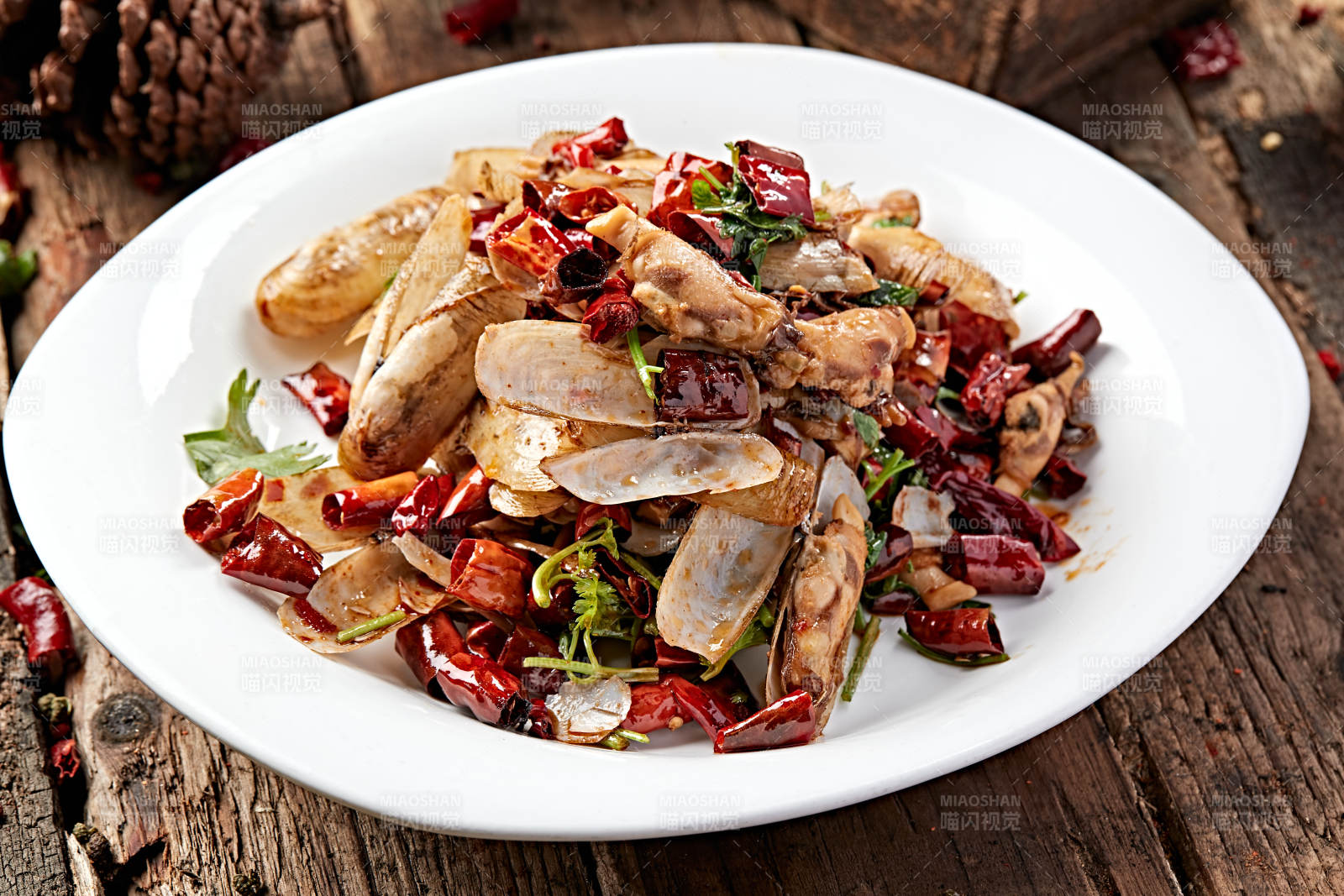 白色圆盘装的辣炒蛏子图片