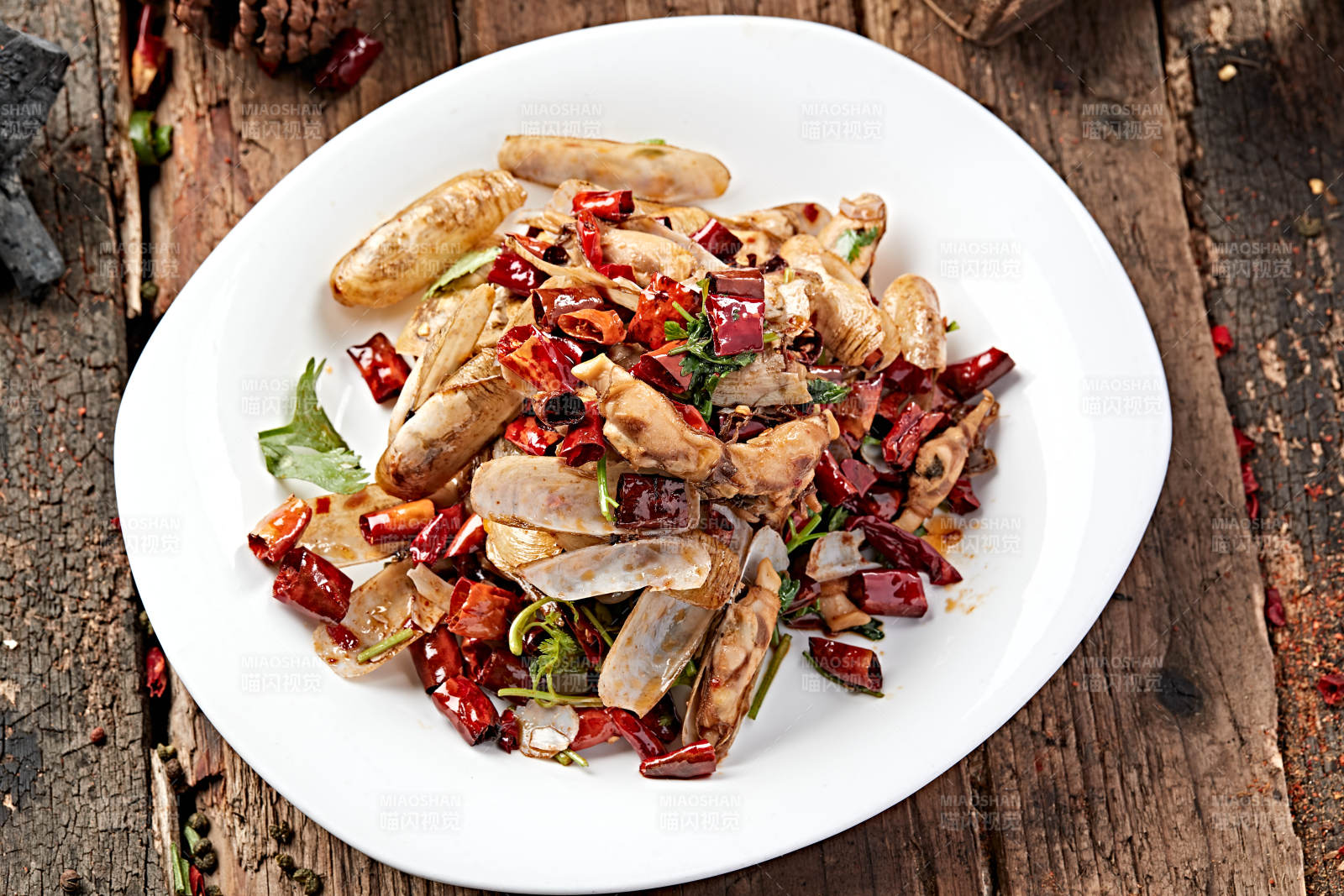 白色圆盘装的辣炒蛏子图片