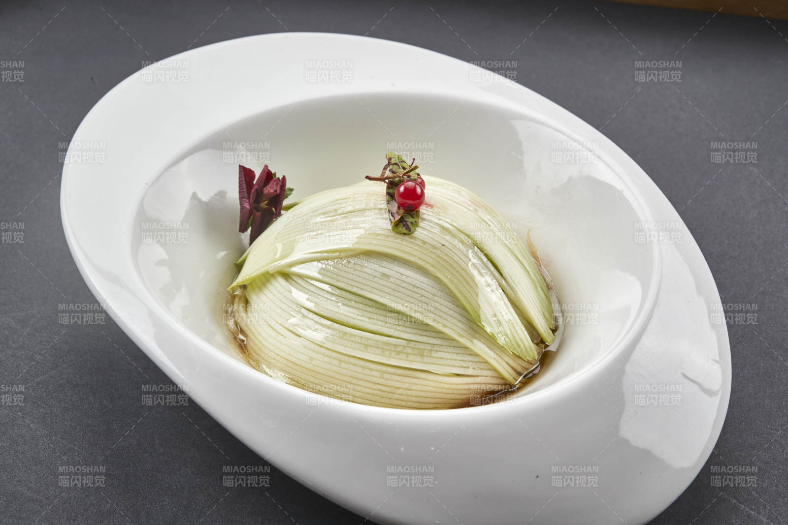 白色椭圆瓷盘装的凉拌浇汁西芹丝图片