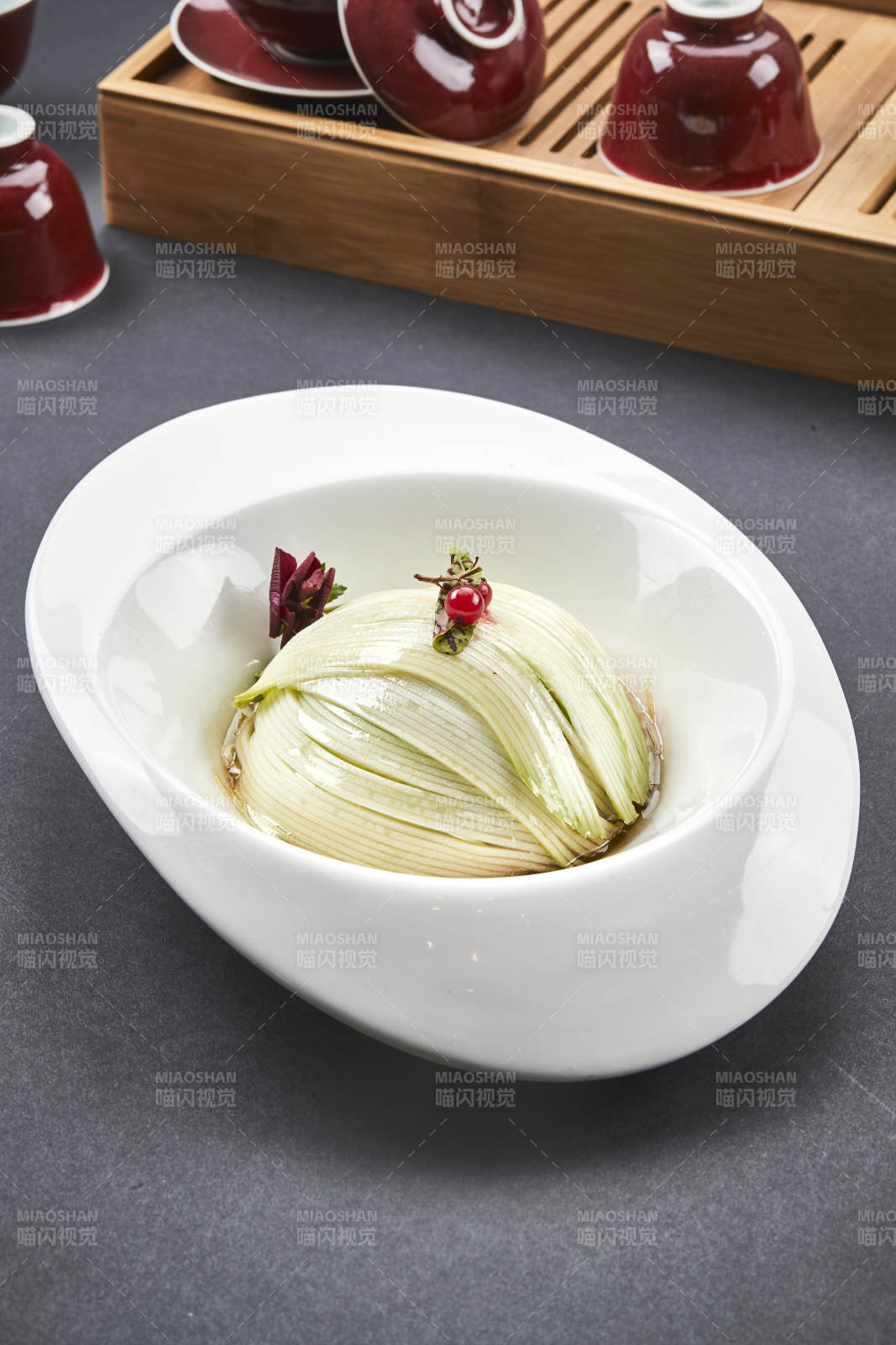 白色椭圆瓷盘装的凉拌浇汁西芹丝图片