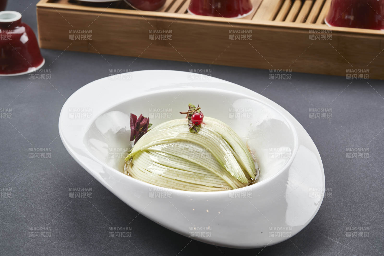 白色椭圆瓷盘装的凉拌浇汁西芹丝图片