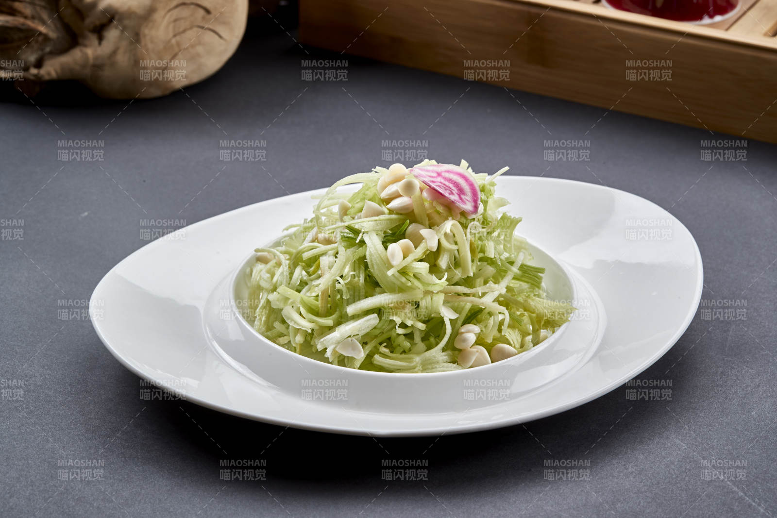 异形白瓷盘装的苦杏仁拌青瓜丝图片