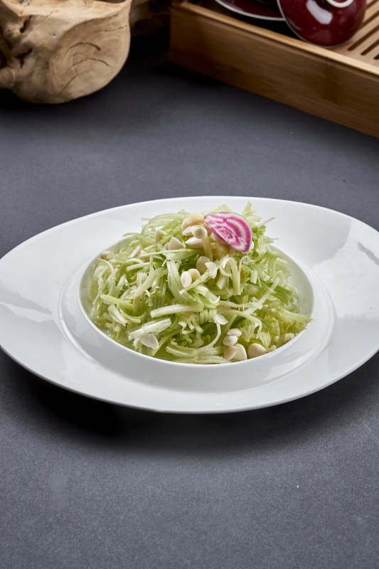 异形白瓷盘装的苦杏仁拌青瓜丝图片