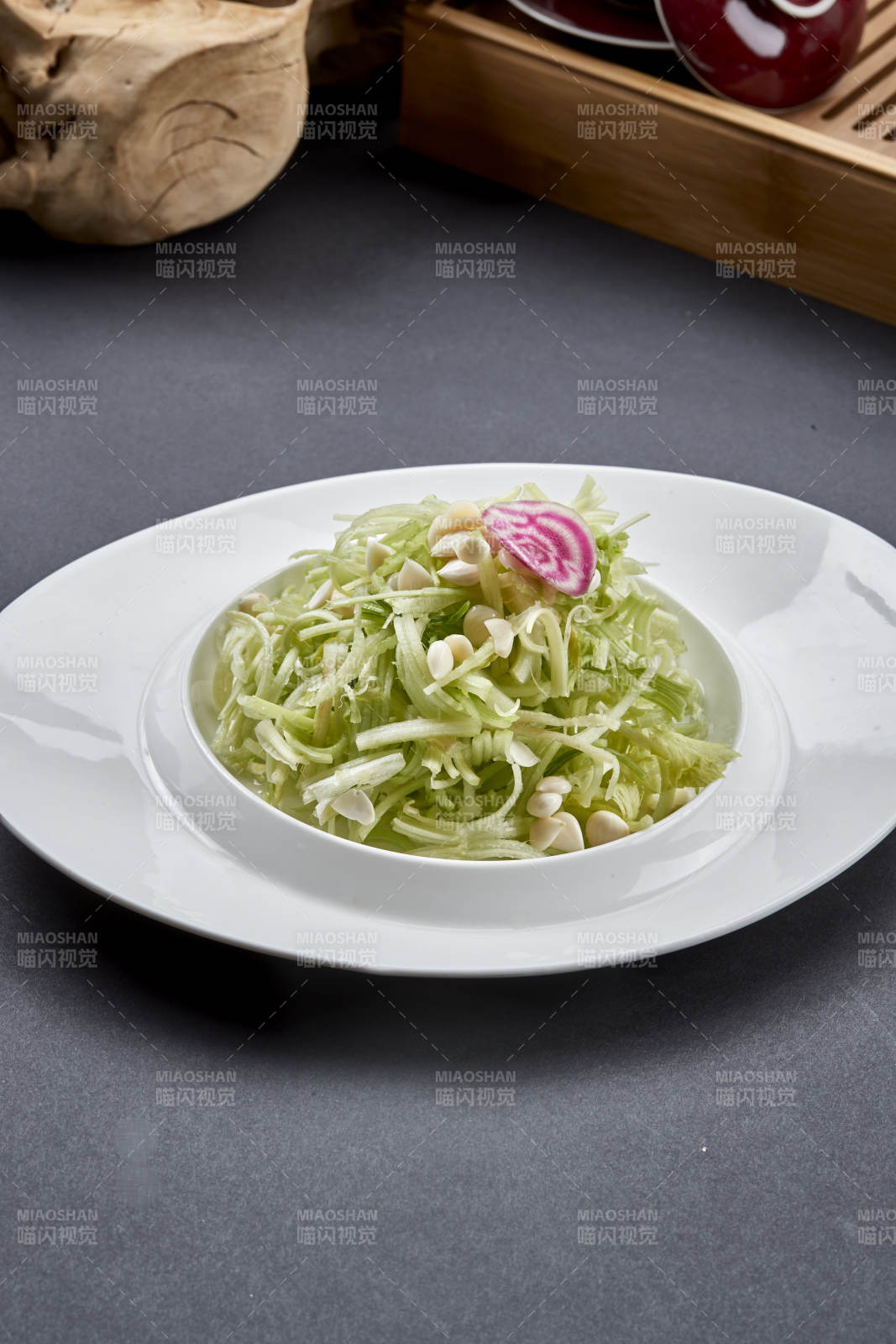 异形白瓷盘装的苦杏仁拌青瓜丝图片