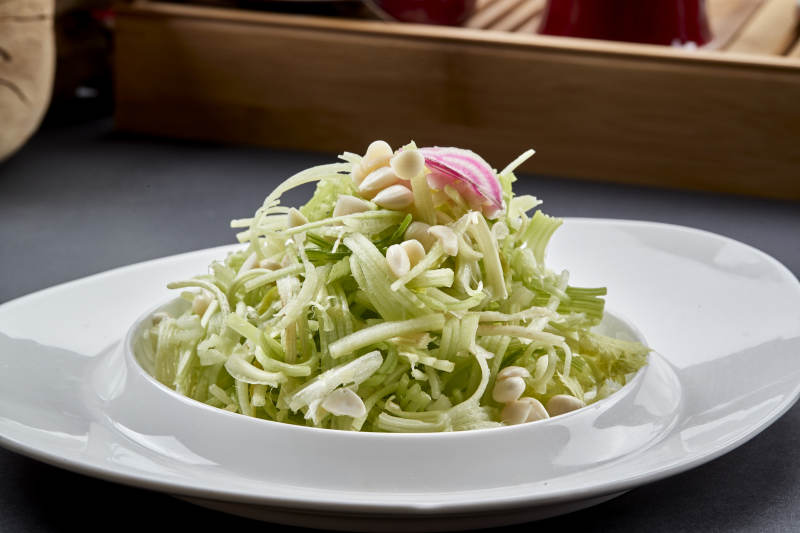 异形白瓷盘装的苦杏仁拌青瓜丝图片