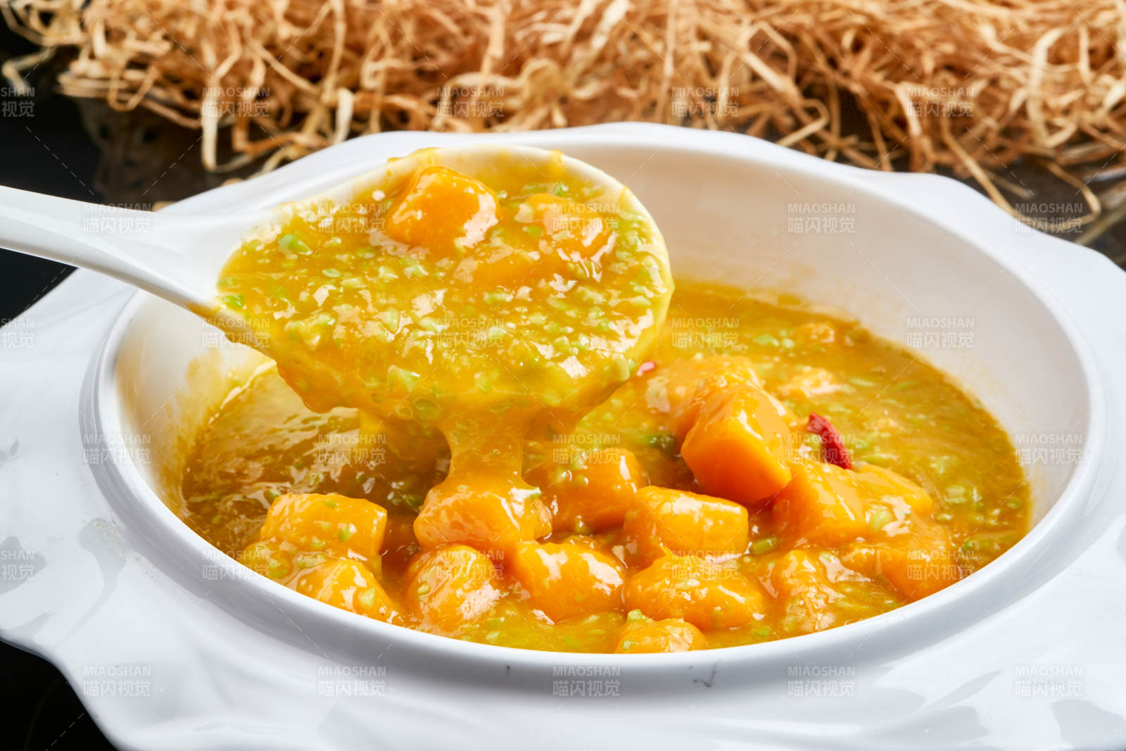 白色瓷餐具装的浓香青豆金米南瓜羹图片