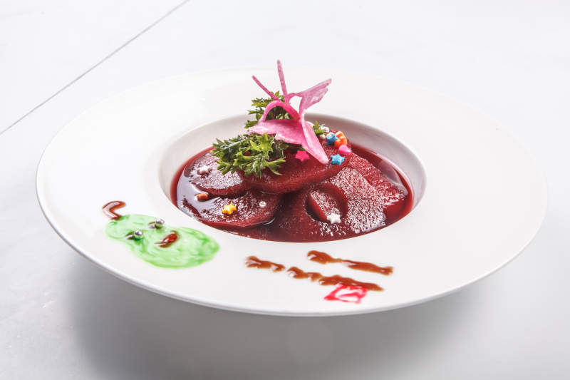 背景上白色瓷盘装的红酒雪梨图片