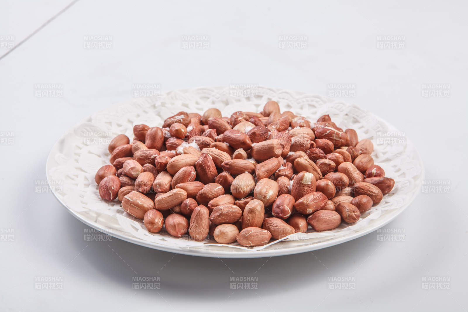 白色瓷盘装的一碟花生米图片