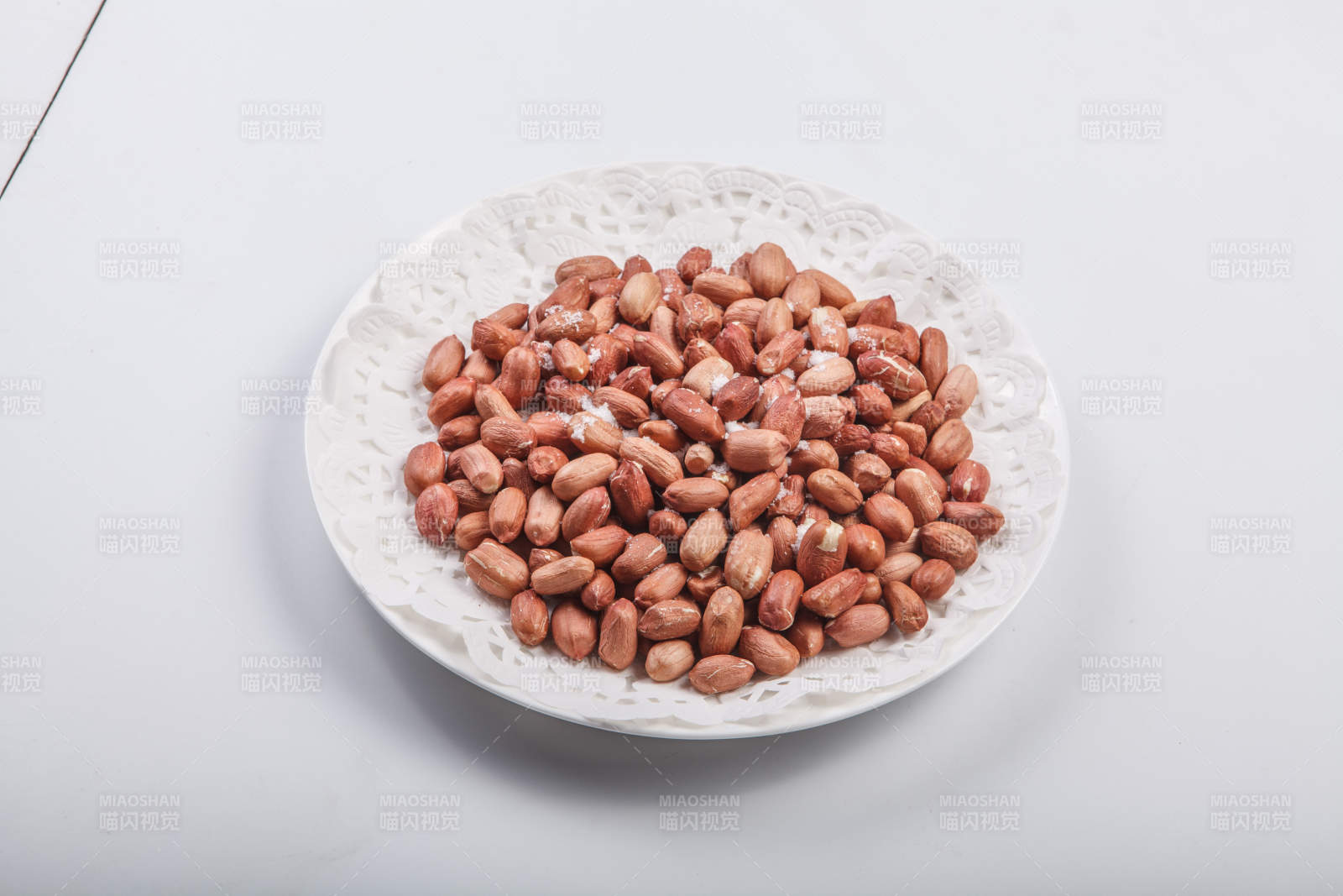 白色瓷盘装的一碟花生米图片