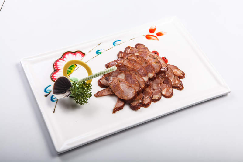 白色瓷盘装的川味麻辣肠图片