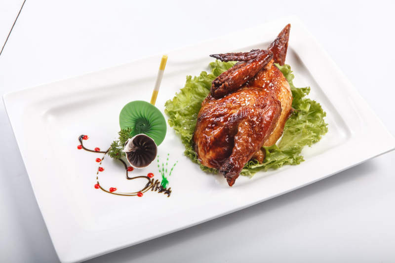 白色瓷盘装的半只脆皮鸡图片