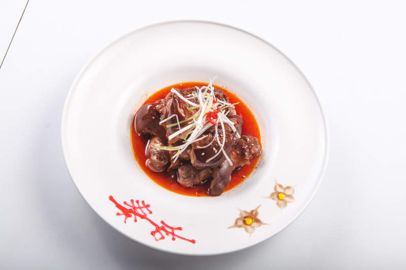 白色瓷盘装的红油卤猪蹄图片