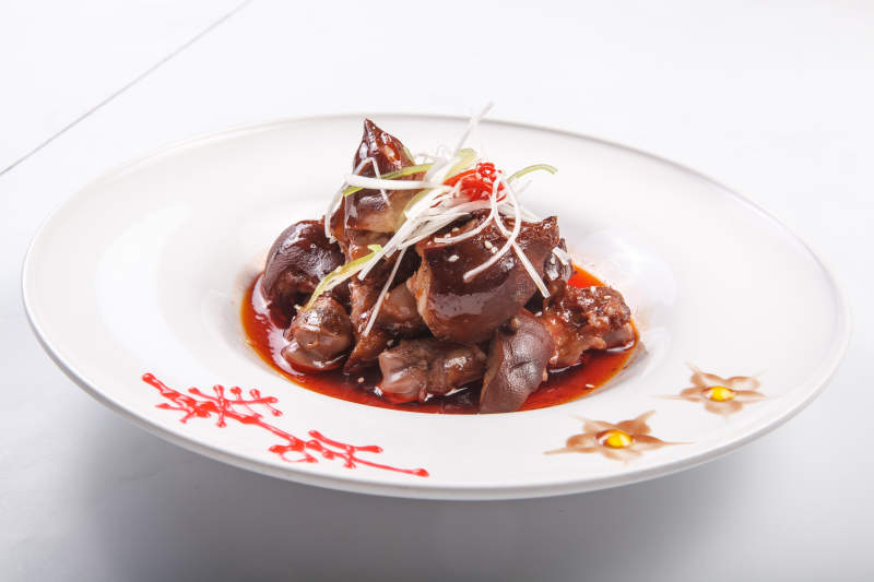 白色瓷盘装的红油卤猪蹄图片
