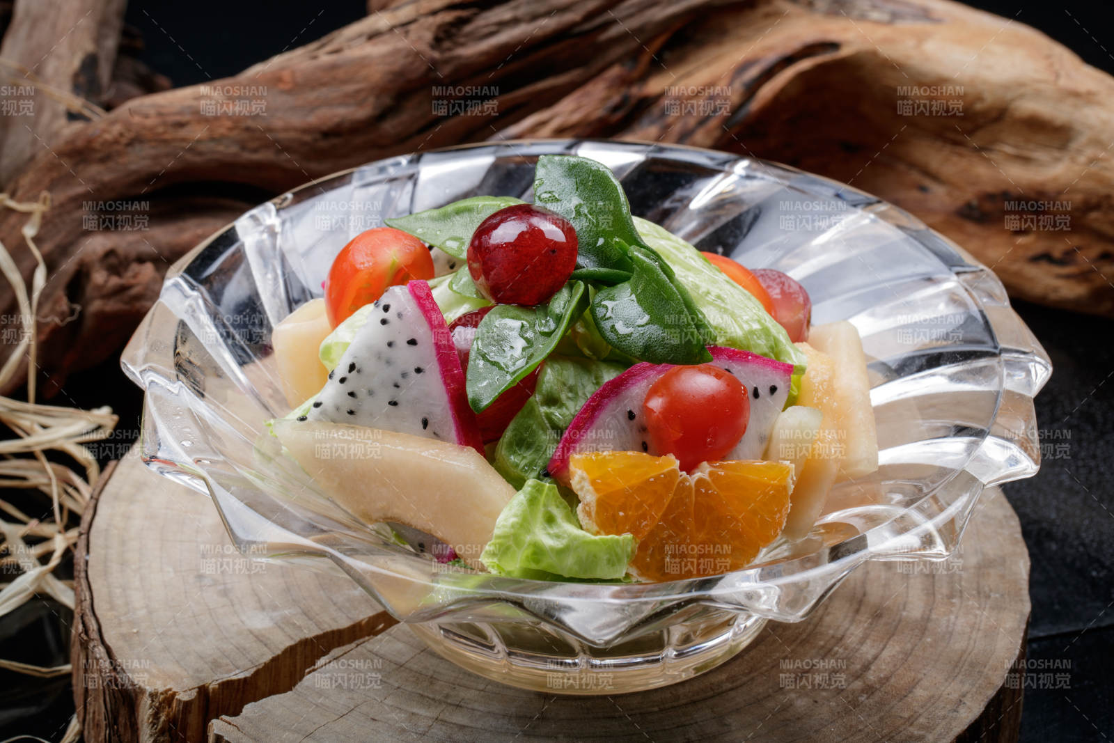 花纹玻璃碗装的果蔬拌菜摆放在樟木砧板上图片