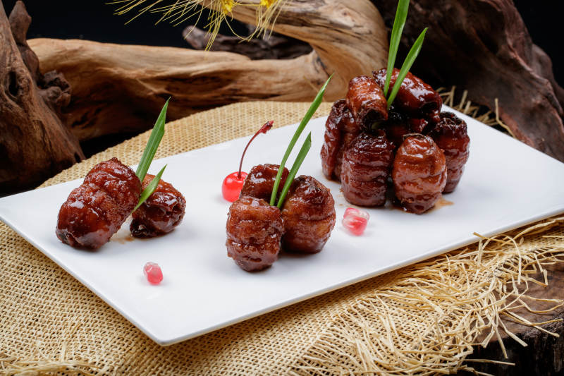 烟熏蜜汁带鱼卷摆放在麻布垫子上图片