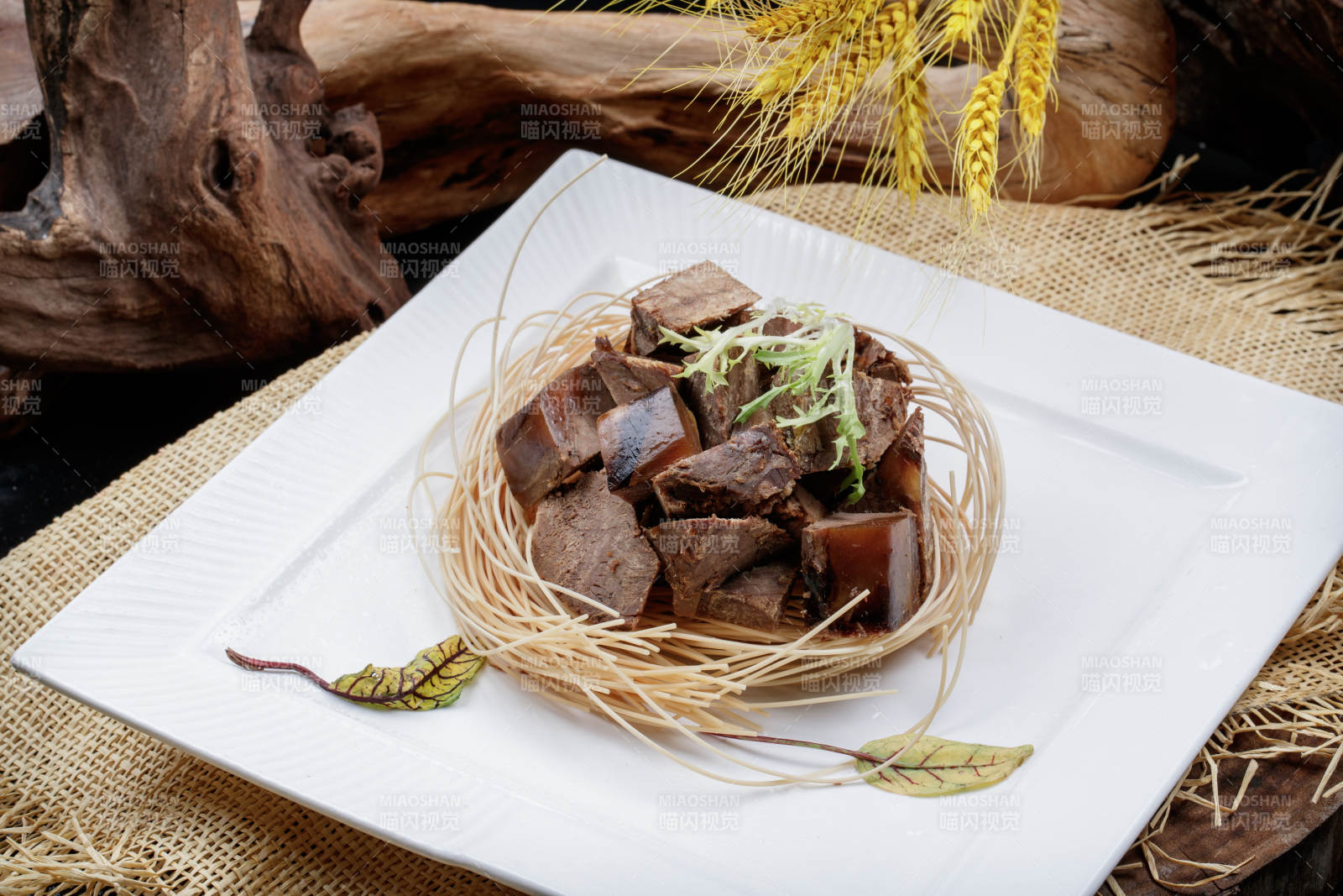 方形瓷盘装的老卤汤牛方粒摆放在麻布垫子上图片