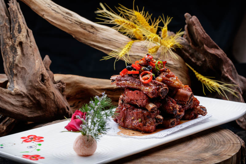 长方形瓷盘装的豆豉蒸排骨摆放在樟木砧板上图片