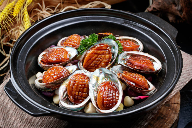 蒜焗砂锅鲜鲍鱼摆放在麻布垫子上图片