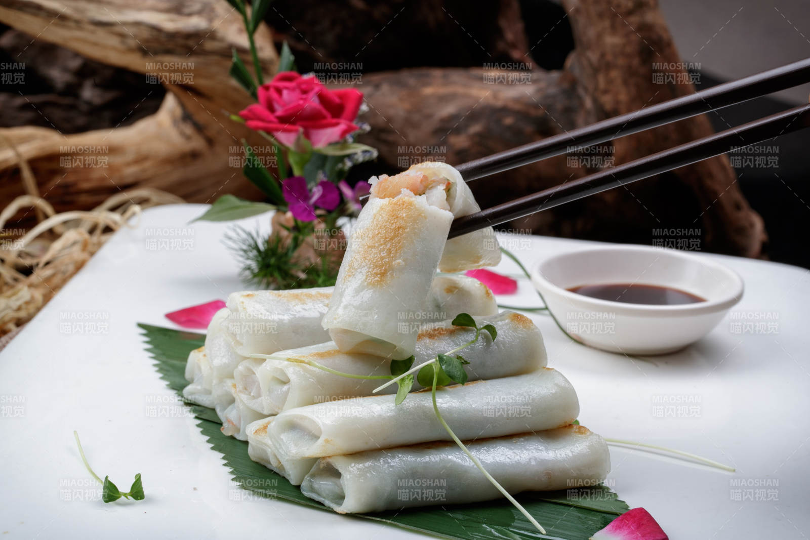 方形瓷盘装的河内肠粉摆放在黑色背景上图片