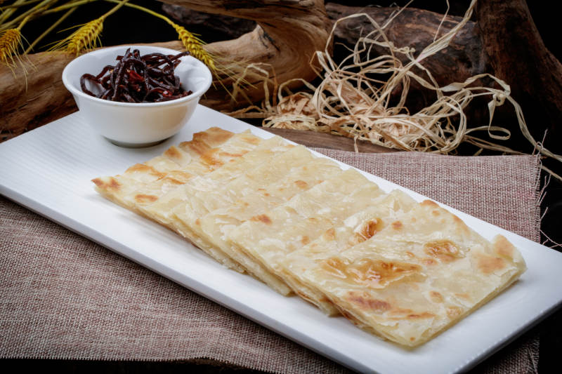 老咸菜香酥饼摆放在麻布垫子上图片