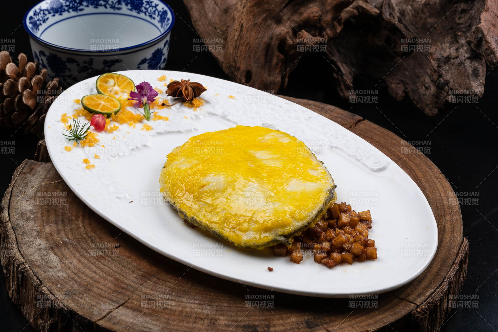 托圆瓷盘装的香煎银鳕鱼摆放在樟木砧板上图片