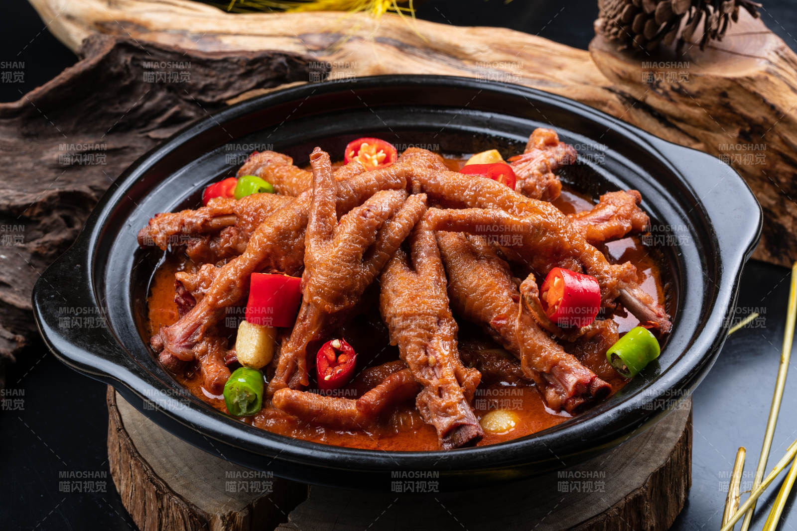 蒜香砂锅煲凤爪摆放在黑色背景上图片