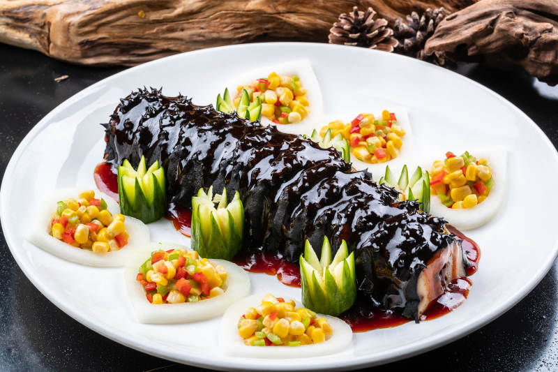 圆瓷盘装的浇汁寿桃梅花参图片