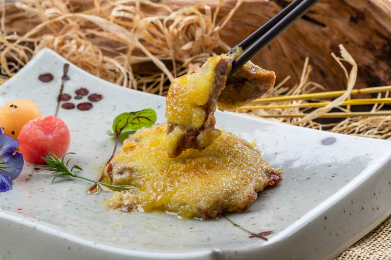 青色瓷盘装的黄金炸猪排摆放在麻布垫子上图片