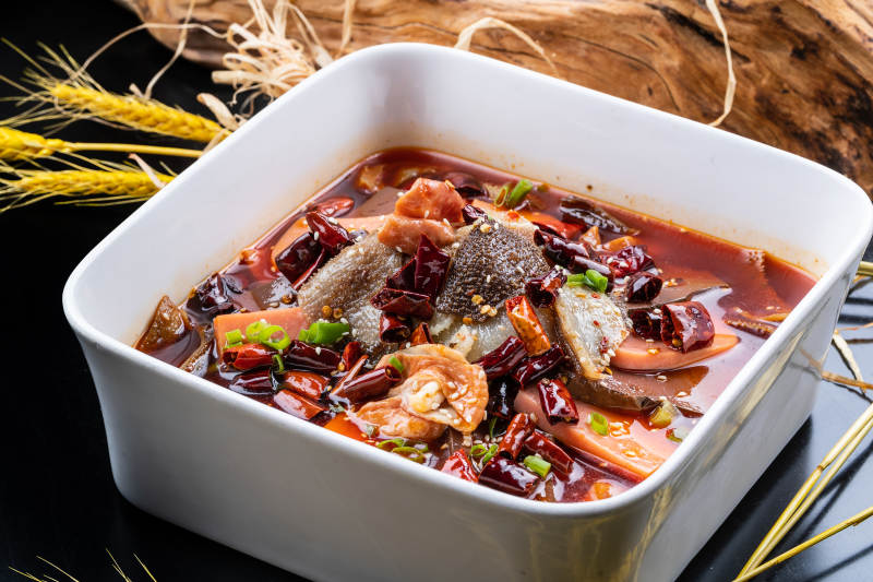 方形汤盆装的川香毛血旺摆放在黑色背景上图片