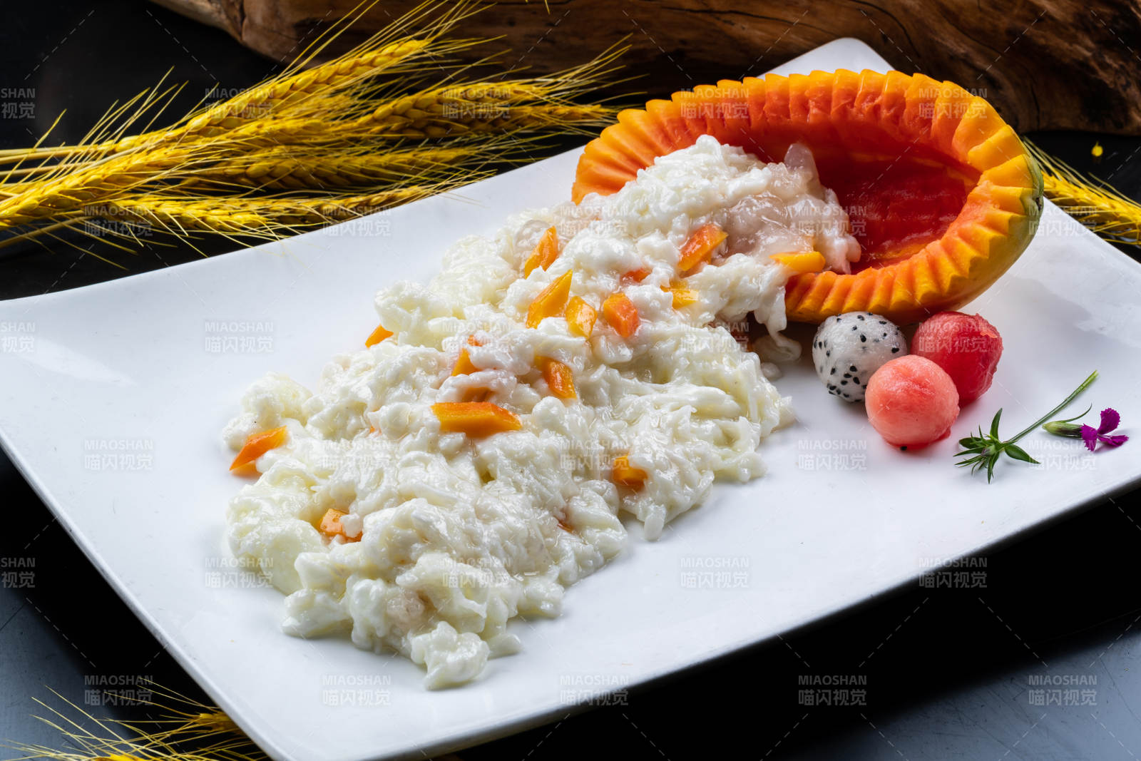 长方形瓷盘装的木瓜芙蓉蛋摆放在黑色背景上图片