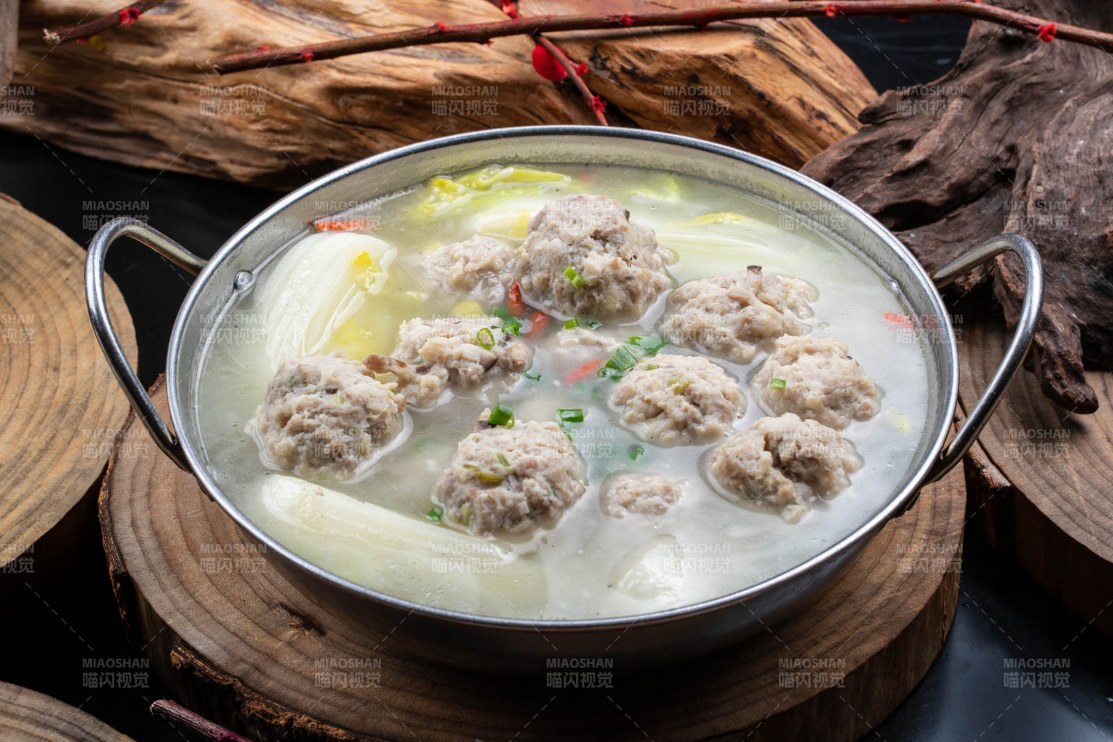 铁锅装的锅仔白菜汤汆丸子摆放在樟木砧板上图片
