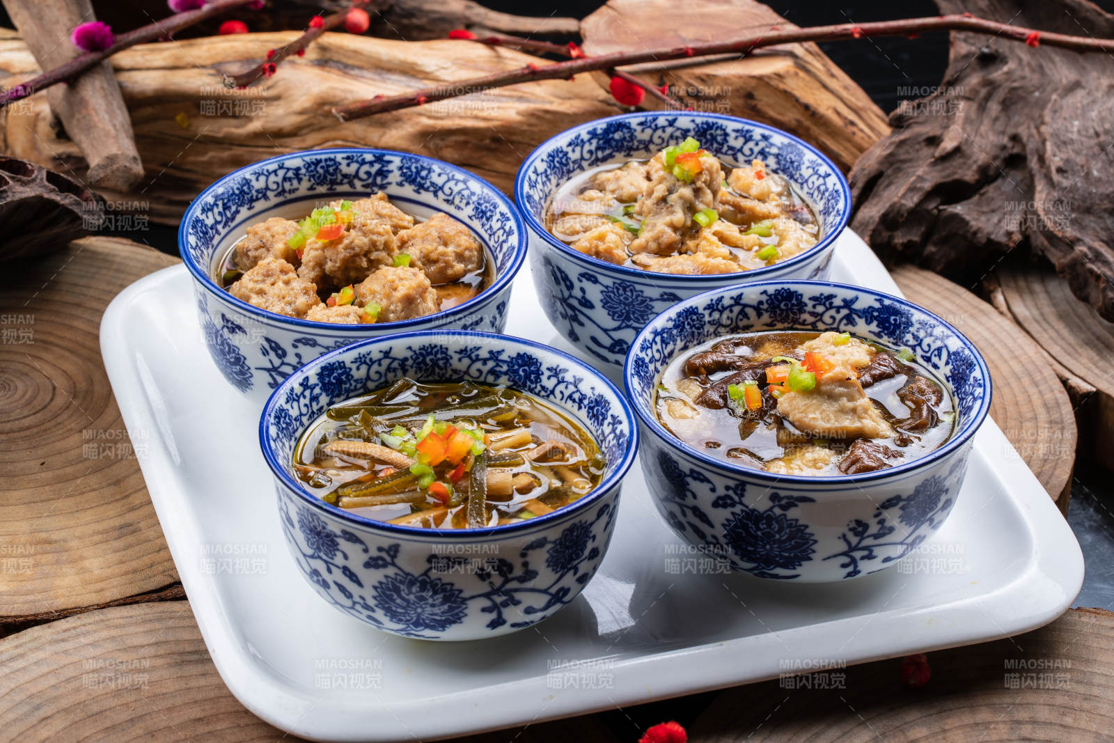 青花瓷碗装的传统四大碗摆放在樟木砧板上图片