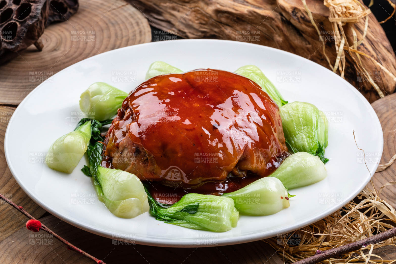 圆形瓷盘装的红焖扣肉摆放在樟木砧板上图片