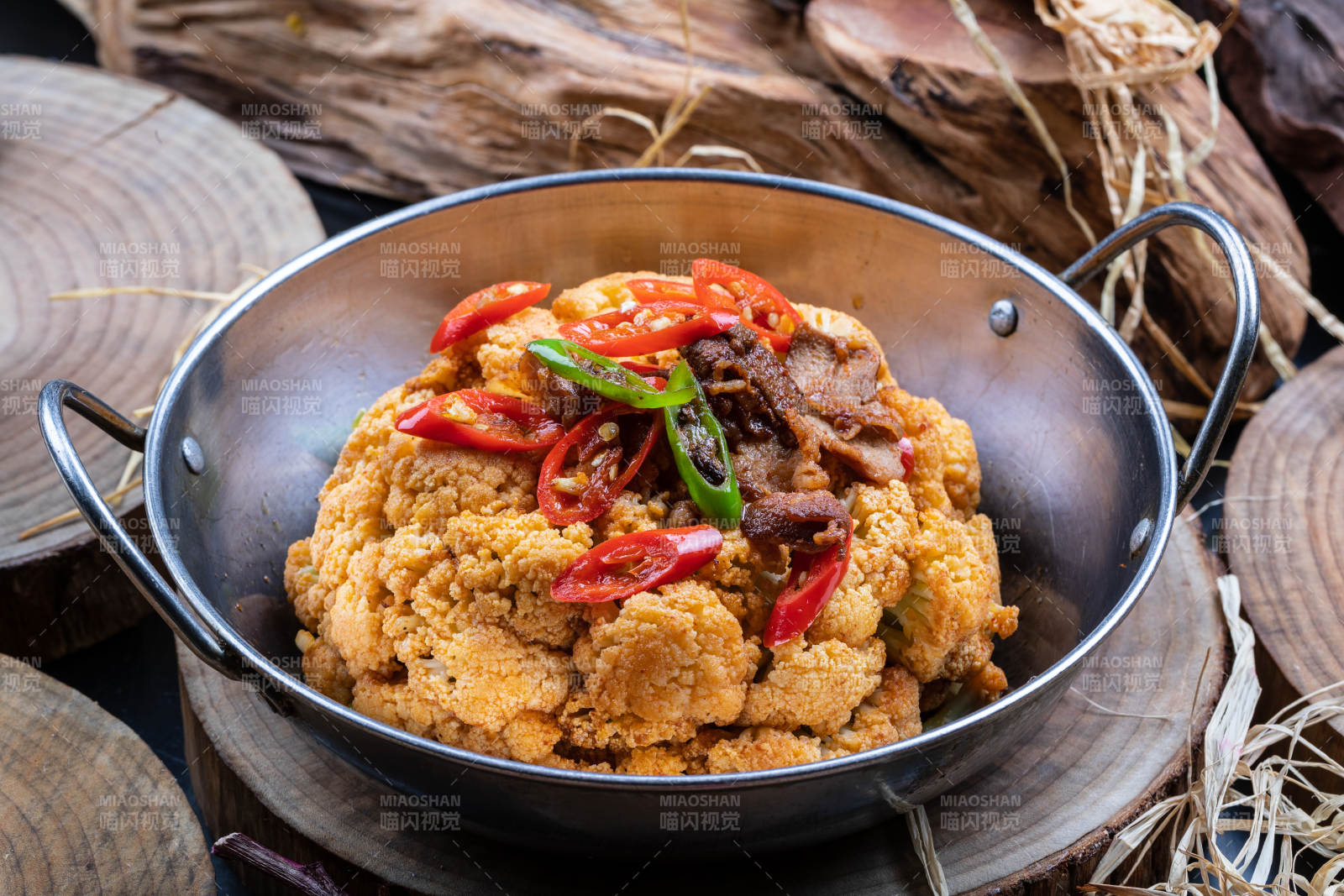 铁锅装的锅仔有机花菜摆放在樟木砧板上图片